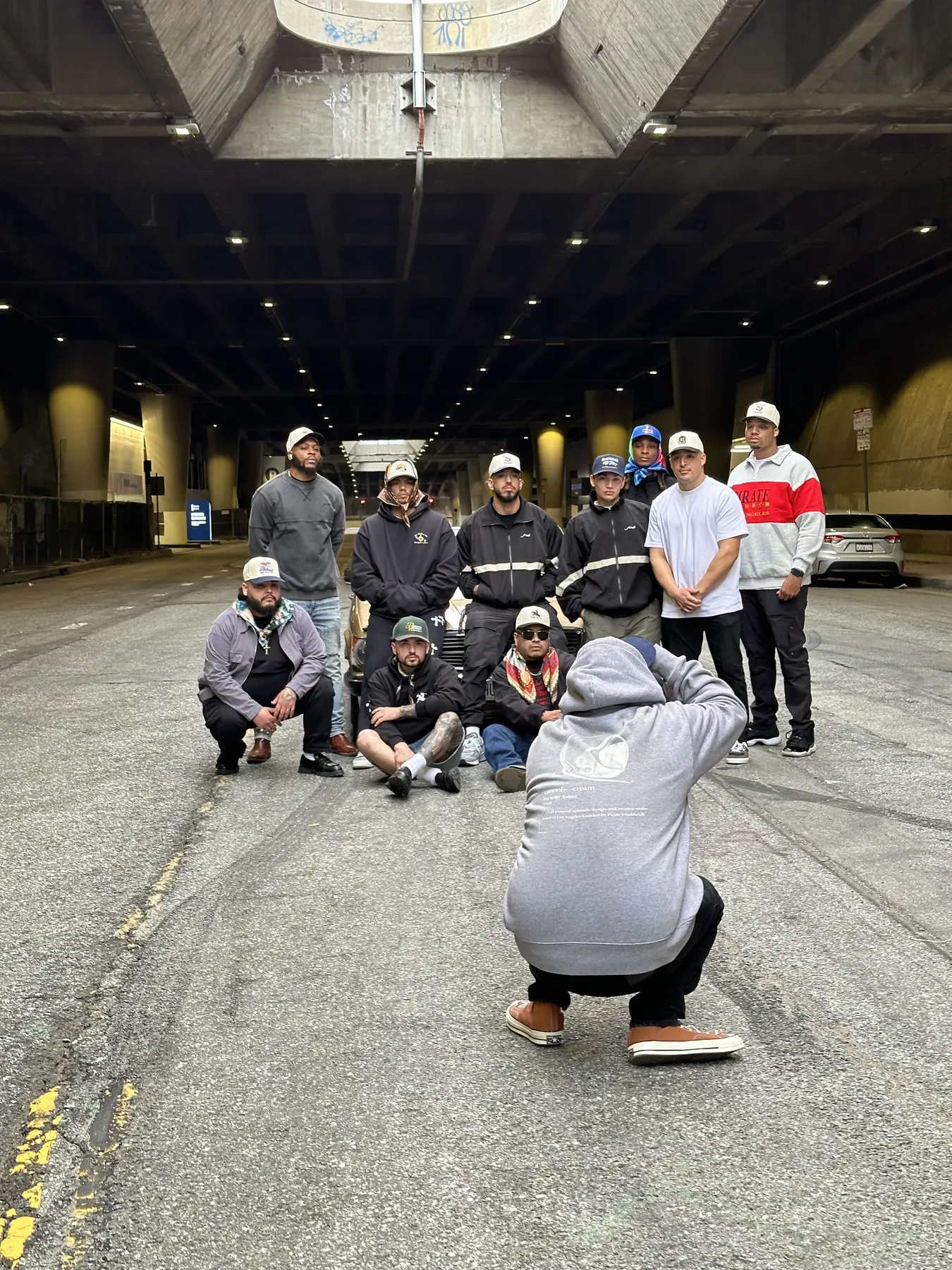 The Pirate Worldwide team poses for a photograph beneath a Los Angeles overpass
