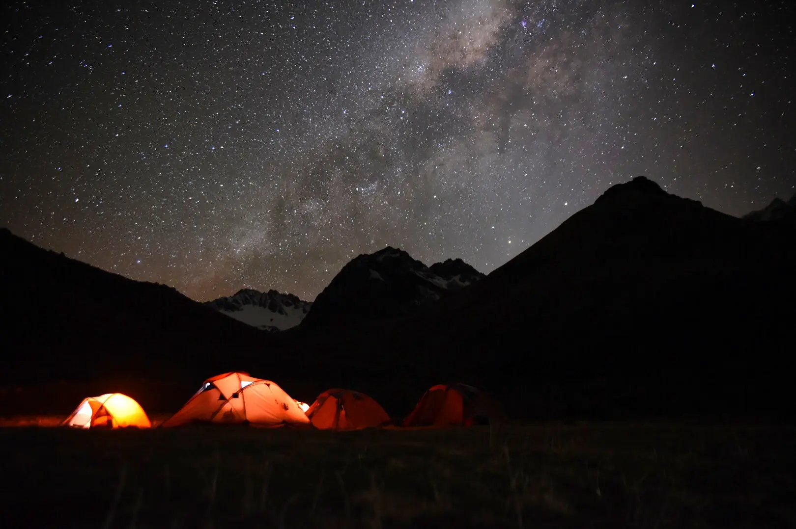 Illuminated tents beneath the Milky Way and Nevado Salkantay